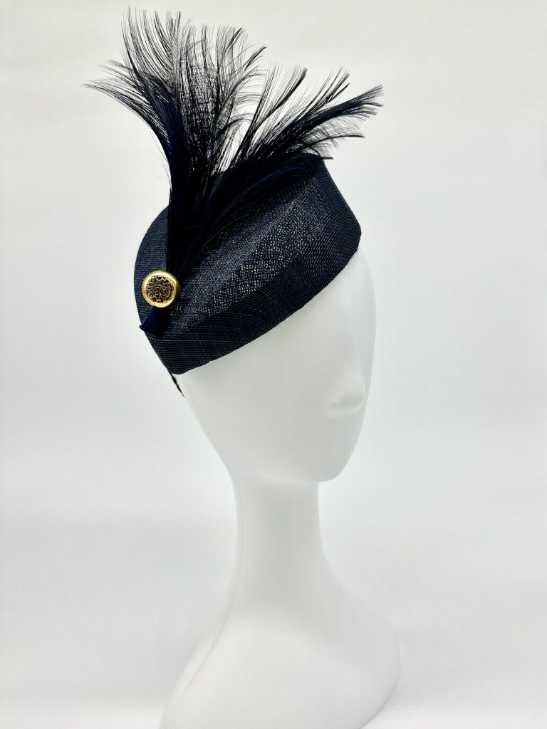 A navy sinamay teardrop style cocktail hat trimmed with navy feathers and gold crested button by Sydney milliner / Australian milliner, Abigail Fergusson Millinery