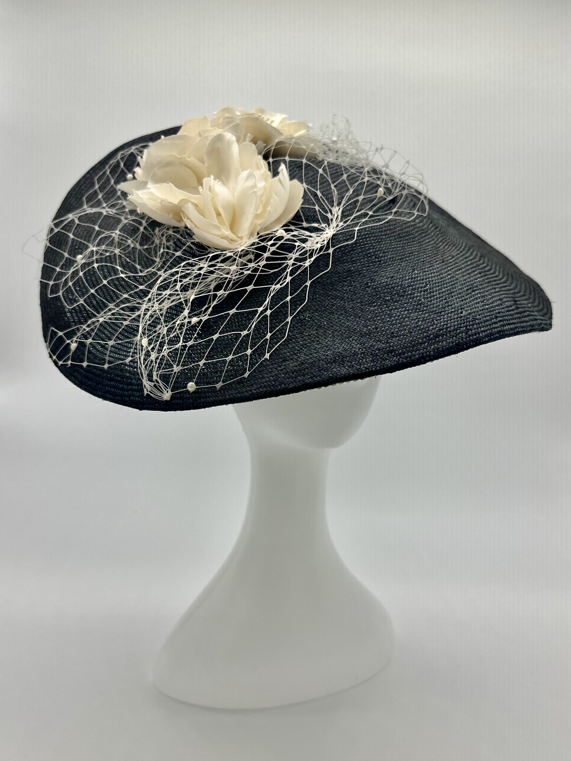 Monochrome Black and ivory saucer hat with ivory silk roses and pearl merry widow veiling and lace braid trim by Australian Milliner Abigail Fergusson available instore at the Milliner's Closet perfect for Championships Day 1 or Derby Day racewear