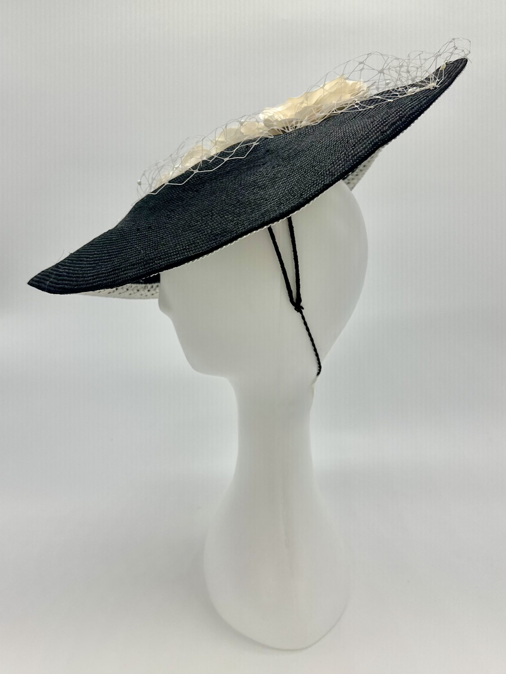 Monochrome Black and ivory saucer hat with ivory silk roses and pearl merry widow veiling and lace braid trim by Australian Milliner Abigail Fergusson available instore at the Milliner's Closet perfect for Championships Day 1 or Derby Day racewear