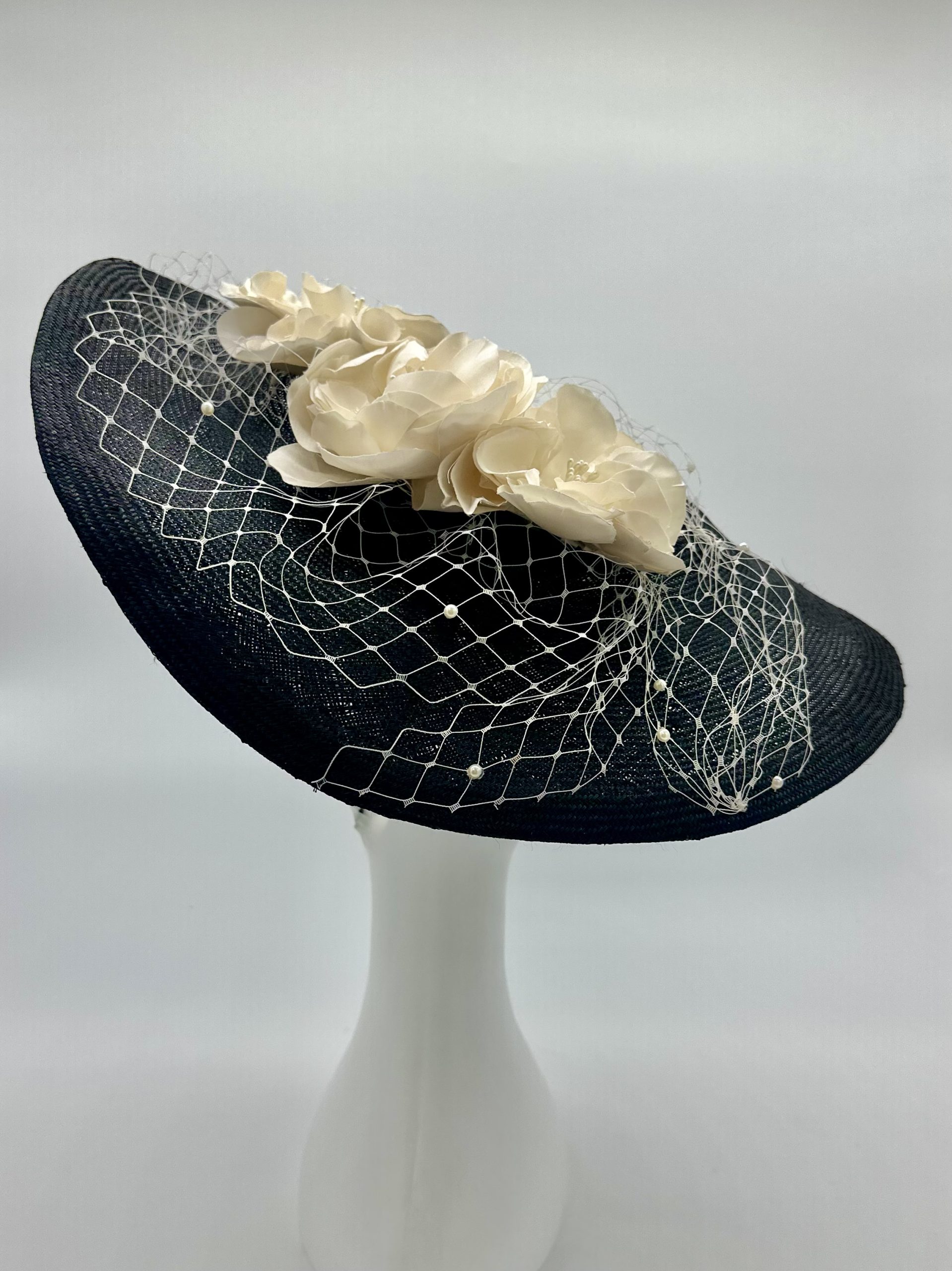 Monochrome Black and ivory saucer hat with ivory silk roses and pearl merry widow veiling and lace braid trim by Australian Milliner Abigail Fergusson available instore at the Milliner's Closet perfect for Championships Day 1 or Derby Day racewear
