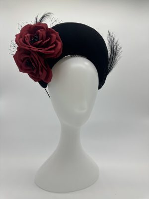 A dramatic and timeless statement piece, this crown halo headpiece is handcrafted from luxurious black rabbit fur felt and is adorned with handcrafted red silk roses at both the front and back, as well as some delicate black feather and veiling trim by Abigail Fergusson Millinery Sydney